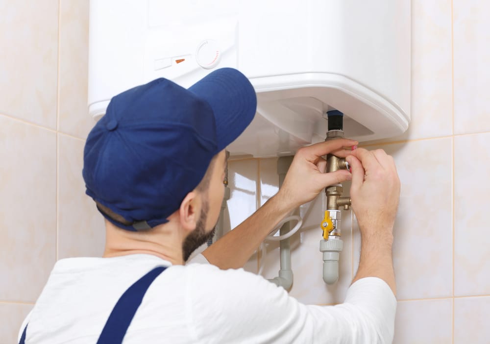 plumber installing a tankless water heater in a home